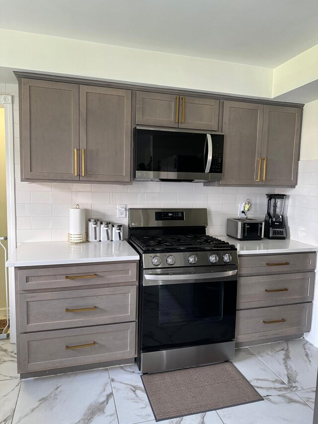 31042 Wellston Dr, Warren, MI 48093 - kitchen featuring decorative backsplash, appliances with stainless steel finishes, marble finish floor, and light countertops