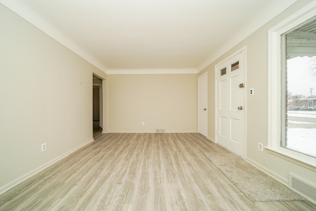 unfurnished room with light wood-style flooring, baseboards, and visible vents
