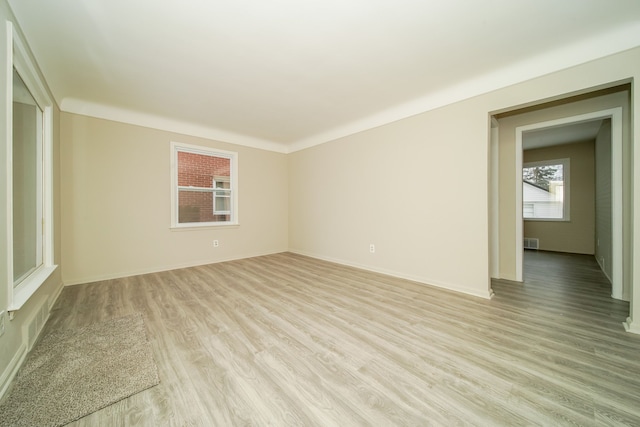 spare room with visible vents, light wood-type flooring, and baseboards