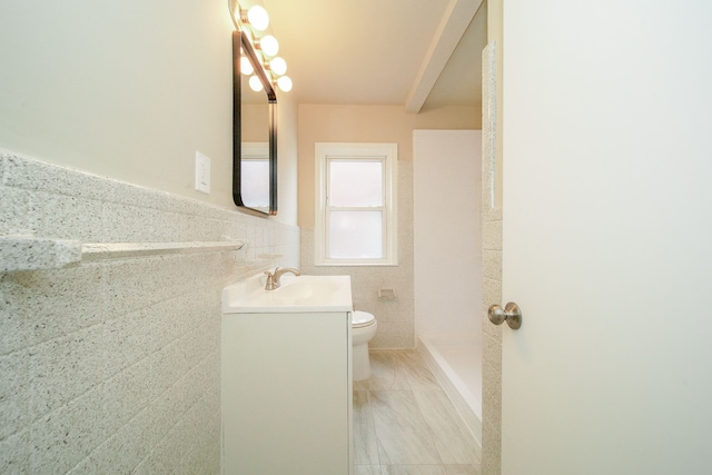 full bathroom with toilet, vanity, a shower, and tile walls