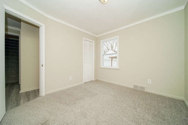 unfurnished bedroom featuring ornamental molding, visible vents, baseboards, and carpet