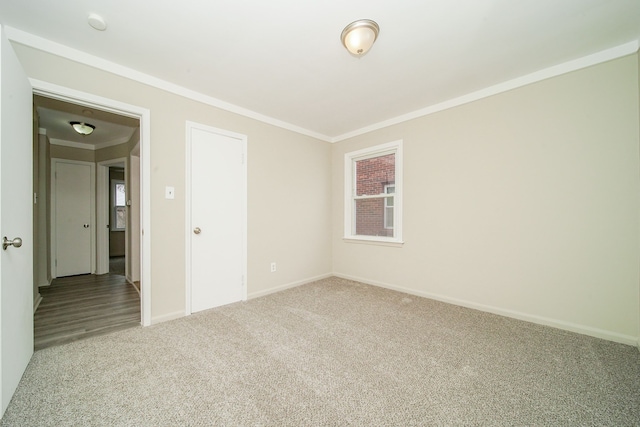empty room featuring baseboards, ornamental molding, and carpet floors