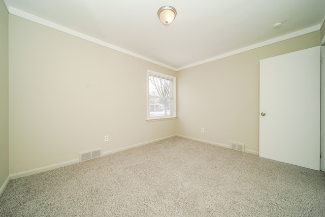 spare room featuring crown molding, baseboards, carpet, and visible vents