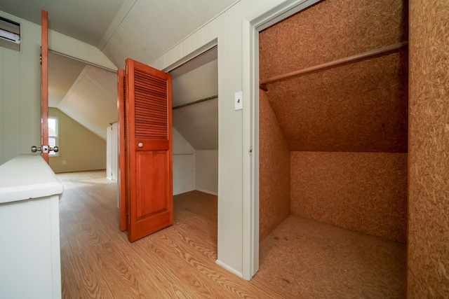 bonus room with vaulted ceiling and light wood-style floors