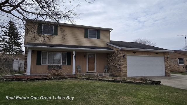 traditional home featuring a front yard, driveway, and an attached garage