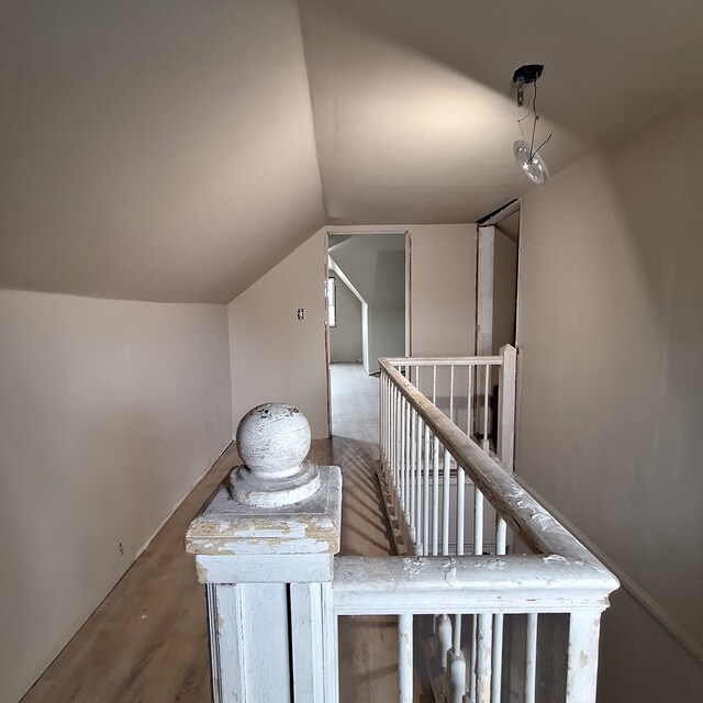 staircase featuring lofted ceiling and wood finished floors