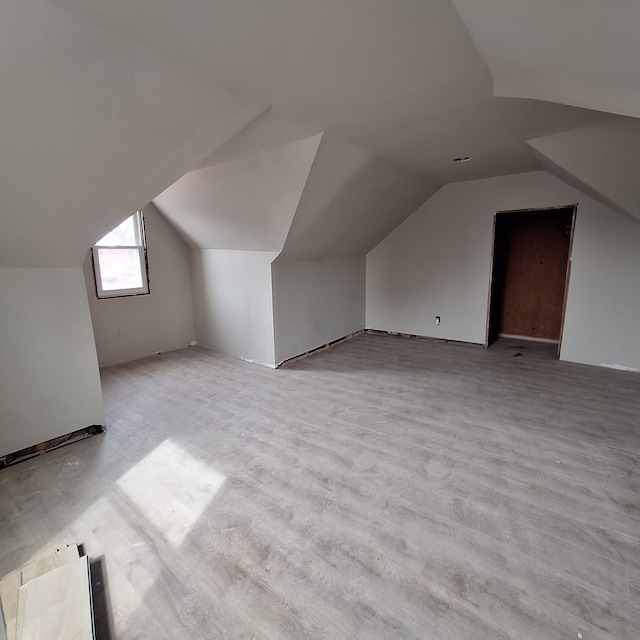 bonus room with vaulted ceiling and light wood finished floors