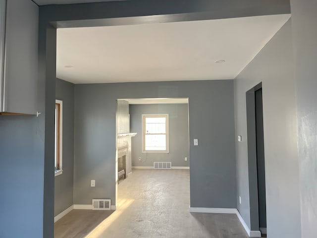 unfurnished room with a fireplace, baseboards, and wood finished floors