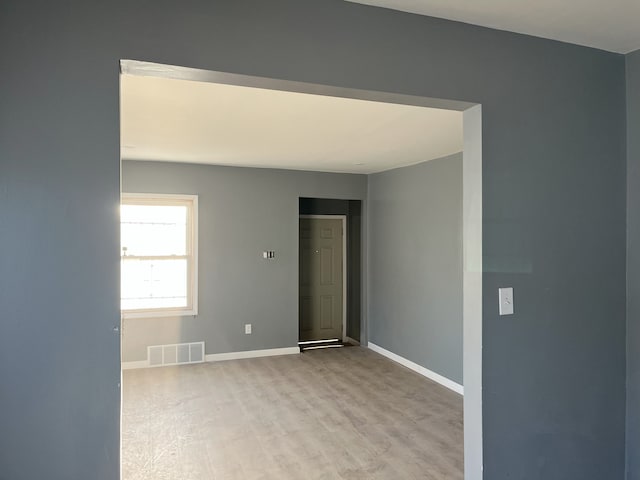 unfurnished room with light wood-type flooring and baseboards