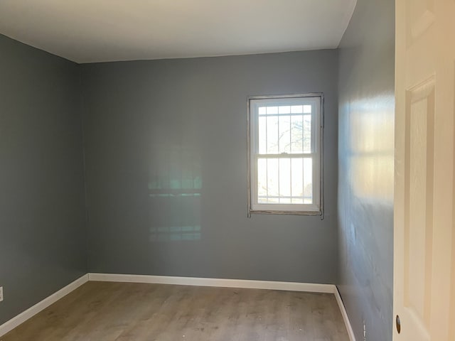 spare room with wood finished floors and baseboards