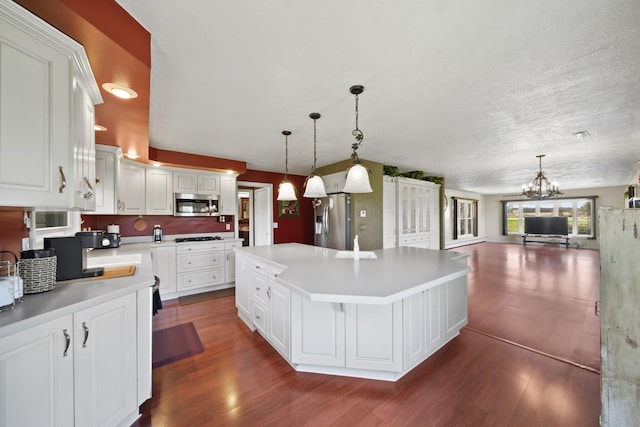 kitchen with a chandelier, a center island, dark wood-style floors, and stainless steel appliances