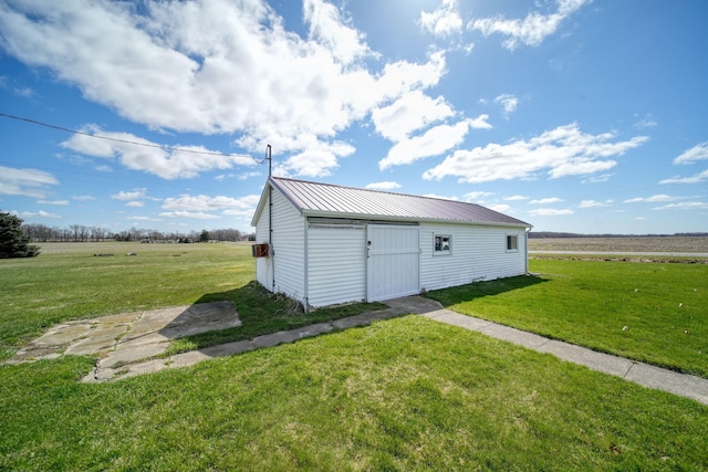 view of pole building with a rural view and a lawn