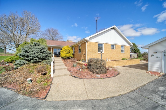single story home with a chimney and brick siding