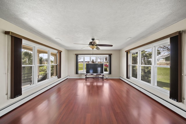unfurnished living room with a textured ceiling, wood finished floors, a baseboard heating unit, and ceiling fan