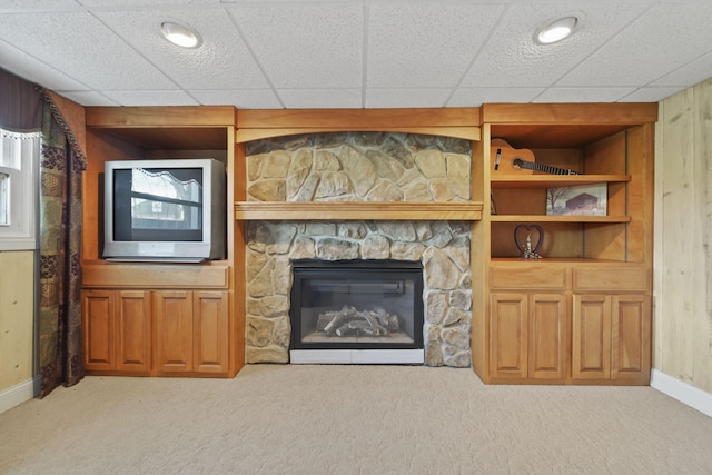 unfurnished living room with a glass covered fireplace, light colored carpet, and baseboards
