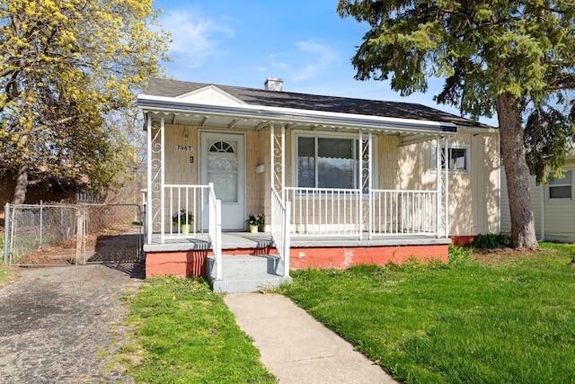 7957 Pine St, Taylor, MI 48180 - bungalow with a front lawn, a shingled roof, and covered porch