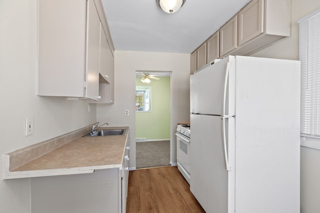 7957 Pine St, Taylor, MI 48180 - kitchen with a sink, ceiling fan, white appliances, light countertops, and wood finished floors