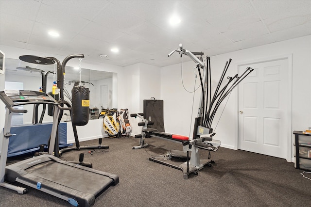 workout area featuring baseboards and a drop ceiling