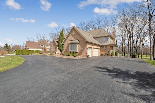 view of front of home with a shingled roof, a garage, a chimney, brick siding, and driveway