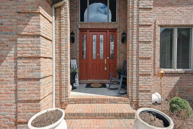 doorway to property featuring brick siding