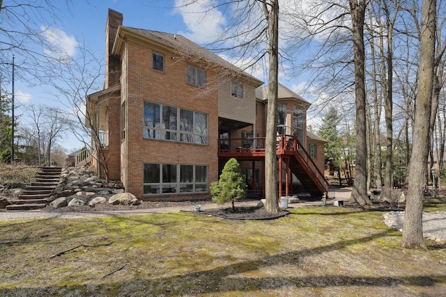 back of house with brick siding, stairway, a deck, and a chimney