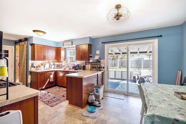 638 Franklin St, Linden, MI 48451 - kitchen featuring tasteful backsplash, light countertops, brown cabinets, and a peninsula