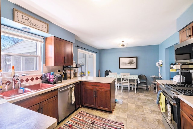 638 Franklin St, Linden, MI 48451 - kitchen featuring stainless steel appliances, a sink, tasteful backsplash, a peninsula, and light countertops