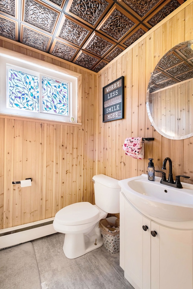 638 Franklin St, Linden, MI 48451 - half bathroom with toilet, wood walls, vanity, and baseboard heating