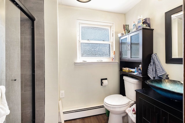 638 Franklin St, Linden, MI 48451 - full bathroom with a baseboard heating unit, a stall shower, toilet, wood finished floors, and vanity