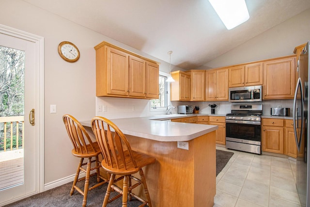 2511 Bowenton Pl SW, Wyoming, MI 49519 - kitchen featuring lofted ceiling, a kitchen breakfast bar, decorative backsplash, stainless steel appliances, and a peninsula