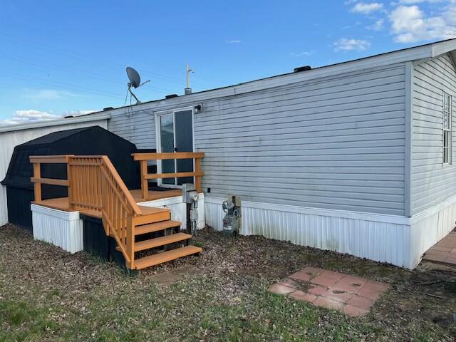 rear view of property featuring a wooden deck
