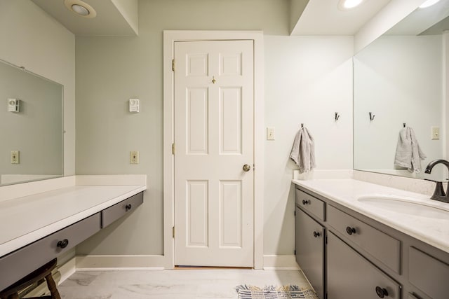 bathroom with vanity, marble finish floor, and baseboards