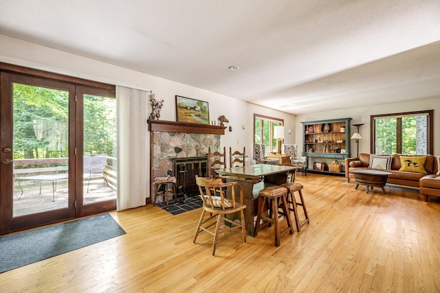 dining space featuring light wood-type flooring and a fireplace