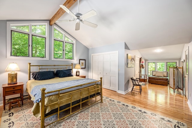 bedroom featuring a ceiling fan, a closet, lofted ceiling with beams, light wood-type flooring, and baseboards