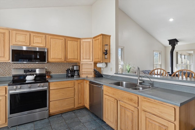 kitchen featuring tasteful backsplash, a sink, dark tile patterned floors, stainless steel appliances, and high vaulted ceiling