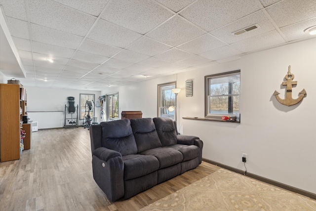living room featuring visible vents, a drop ceiling, and wood finished floors