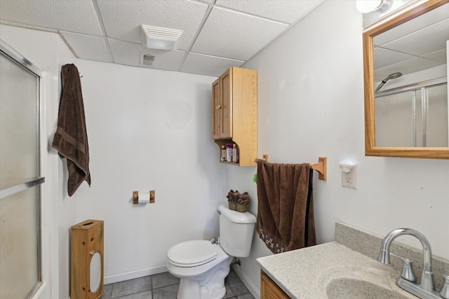 full bathroom featuring a shower with door, tile patterned floors, visible vents, and a drop ceiling