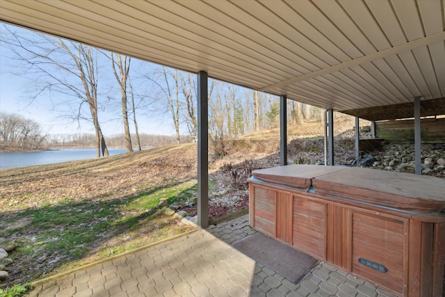 view of patio featuring a hot tub and a water view