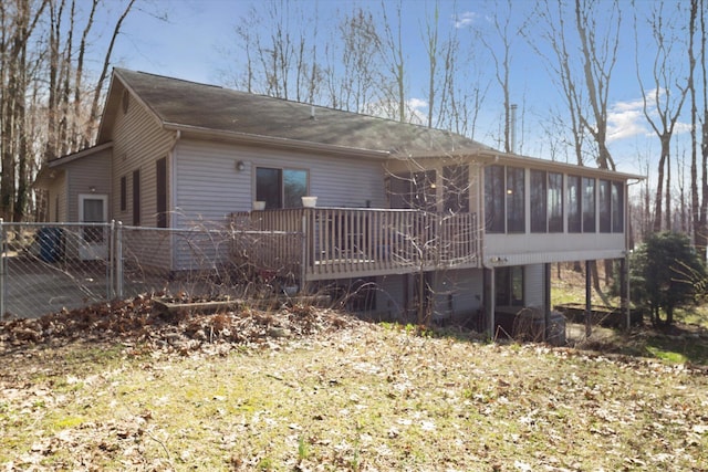 back of property with a sunroom and fence