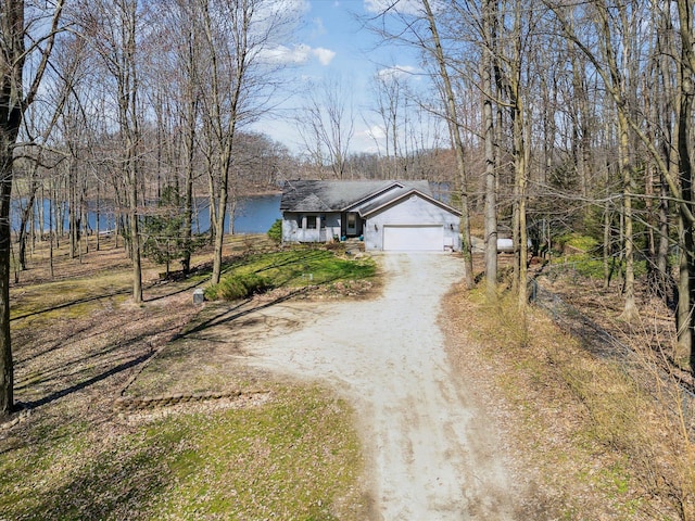 ranch-style home featuring a garage and dirt driveway