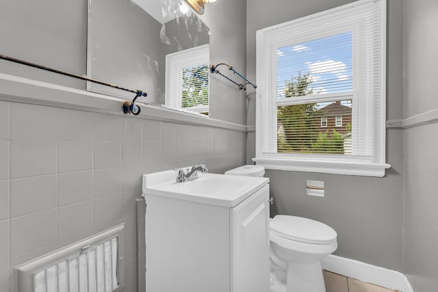 5767 Berkshire St, Detroit, MI 48224 - bathroom featuring tile walls, toilet, plenty of natural light, tile patterned floors, and wainscoting