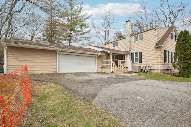 27423 W 12 Mile Rd, Farmington Hills, MI 48334 - view of front facade with central air condition unit, a chimney, aphalt driveway, and a garage