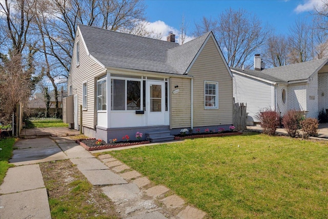 bungalow featuring a chimney, a front lawn, entry steps, concrete driveway, and roof with shingles