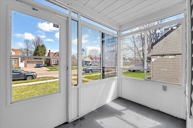 unfurnished sunroom with a healthy amount of sunlight and a residential view