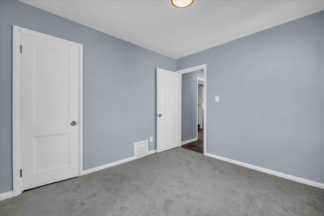 unfurnished bedroom featuring baseboards, visible vents, and carpet