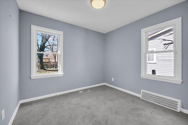 carpeted empty room featuring baseboards and visible vents