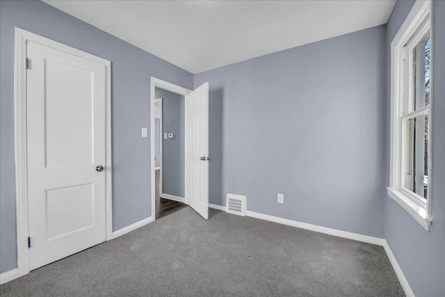 unfurnished bedroom featuring baseboards, visible vents, and carpet