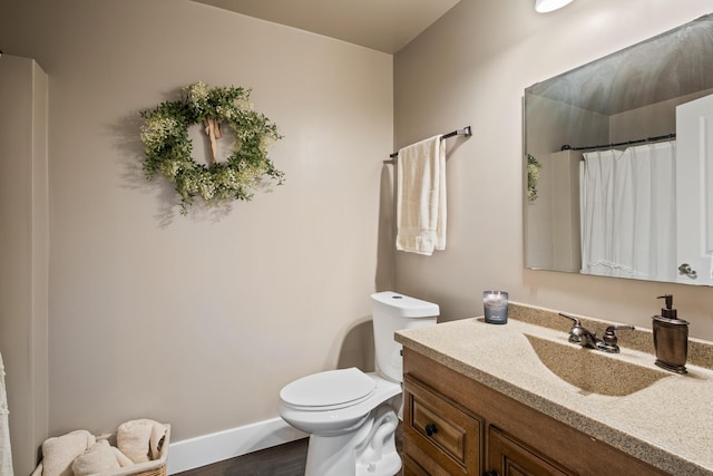 full bathroom featuring vanity, toilet, curtained shower, wood finished floors, and baseboards