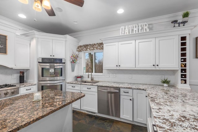 kitchen with dark stone countertops, backsplash, a ceiling fan, stainless steel appliances, and a sink