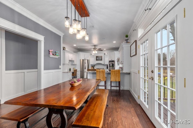 dining area featuring dark wood-style flooring, ornamental molding, recessed lighting, ceiling fan with notable chandelier, and french doors